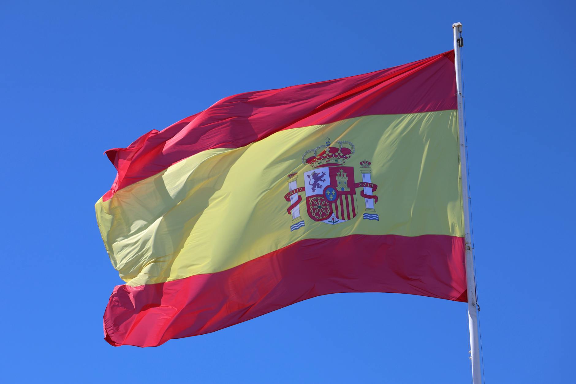 spanish national flag waving in clear sky