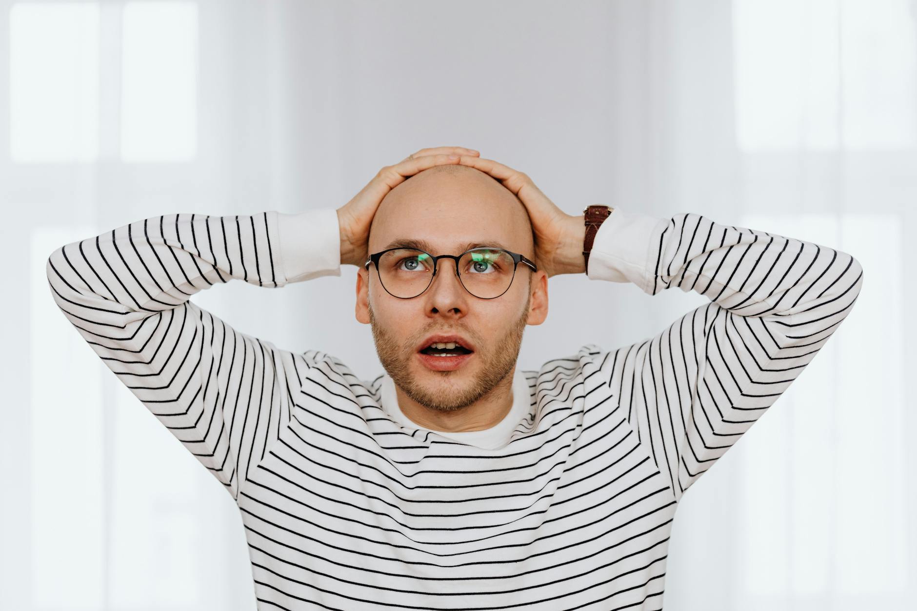 a man holding his bald head