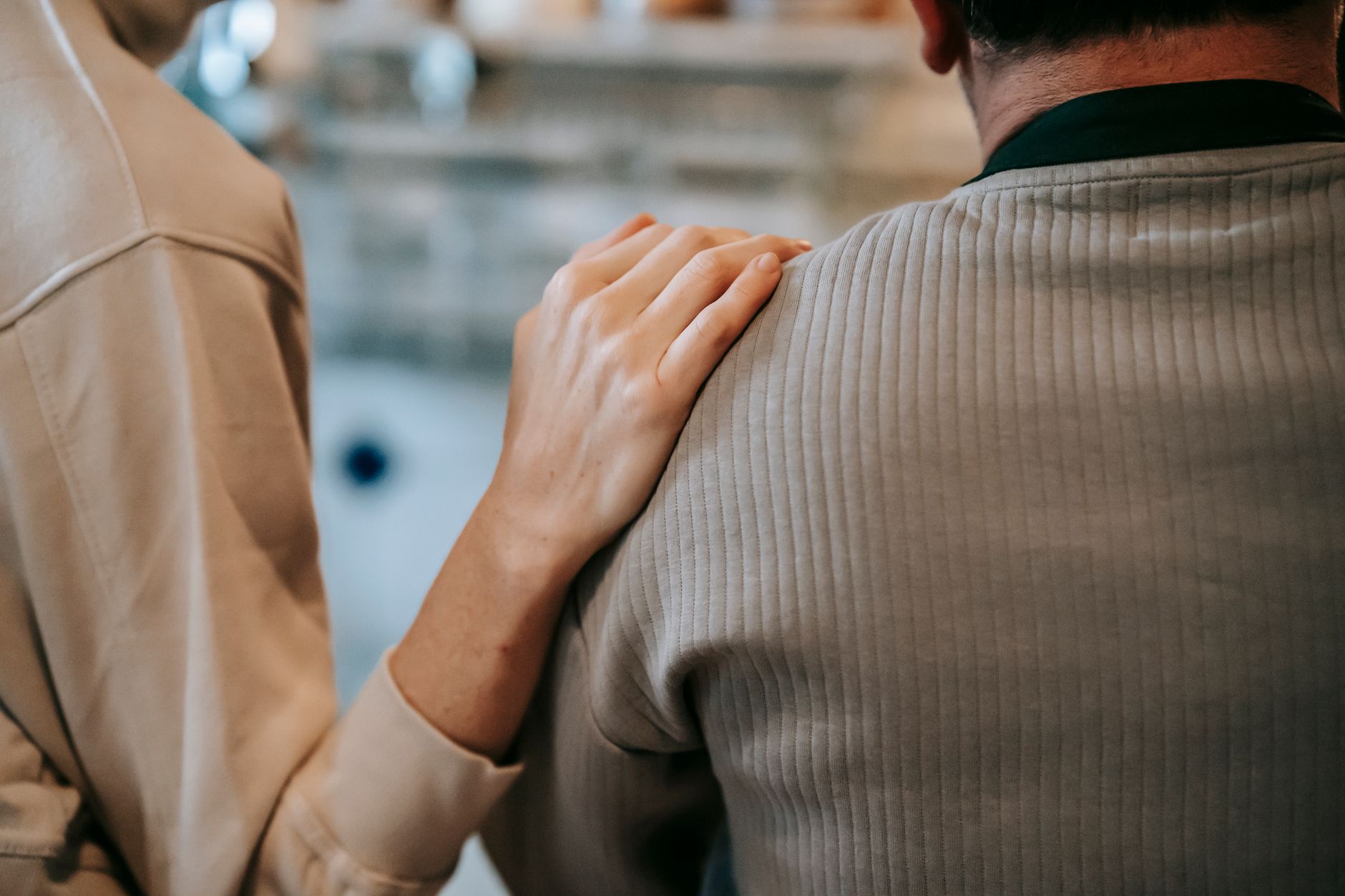 unrecognizable woman touching shoulder of man at home