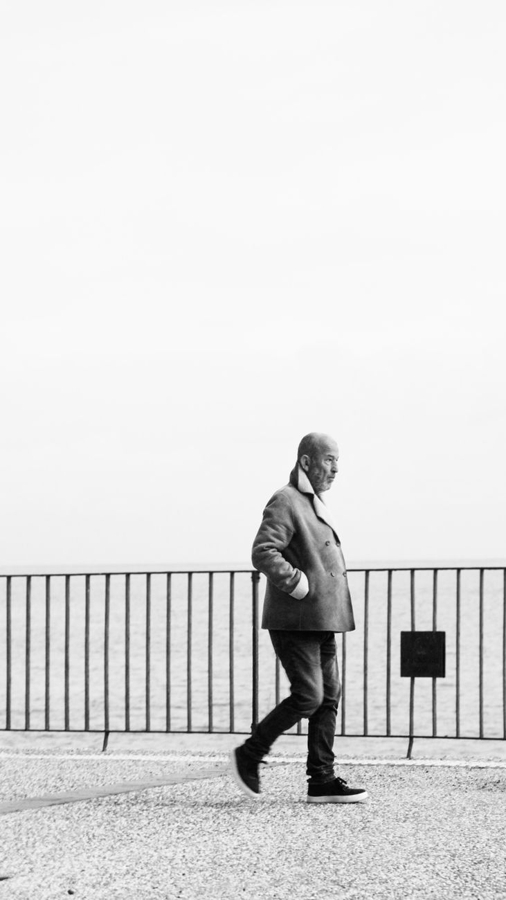 a man walking down the street with his hands in his pockets